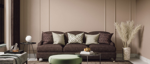 Wohnzimmer mit braunem Sofa und Cappucino Wandfarbe