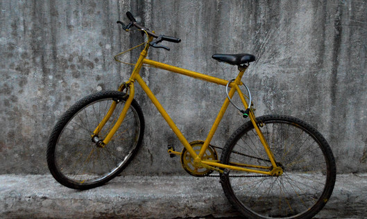 Gelbes Fahrrad vor einer Mauer