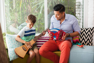 Junger Mann musiziert mit Kind