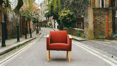 Roter Sessel steht mitten auf einer Straße