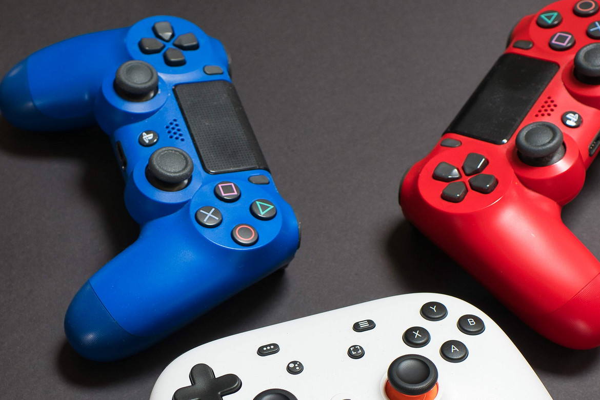 Ein blauer, ein roter und ein weißer Controller auf schwarzem Untergrund