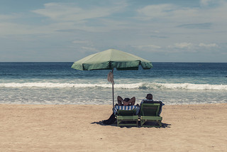 Strand mit Menschen unter dem Sonnenschirm