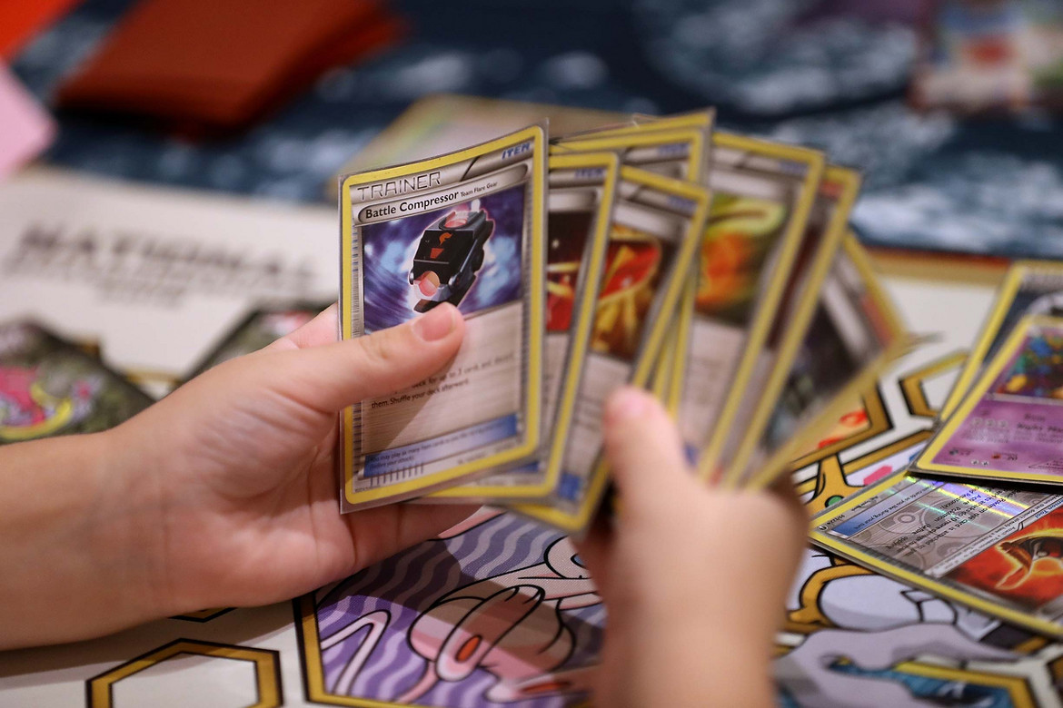 Kinderhand hält ganz viele wertvolle Pokémon-Karten