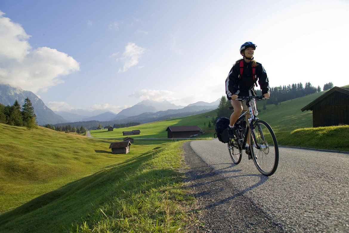 gebrauchte Fahrräder verkaufen, Eine Person auf einem Fahrrad mit bergiger Landschaft im Hintergrund