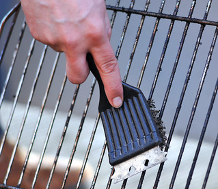 cleaning the grill with scrubber