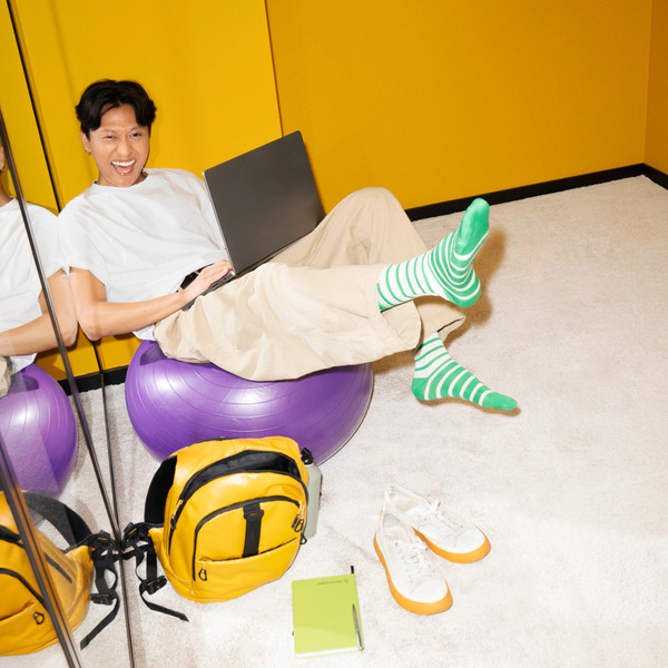 Persons sits on a gymnastic ball with a laptop on the lap