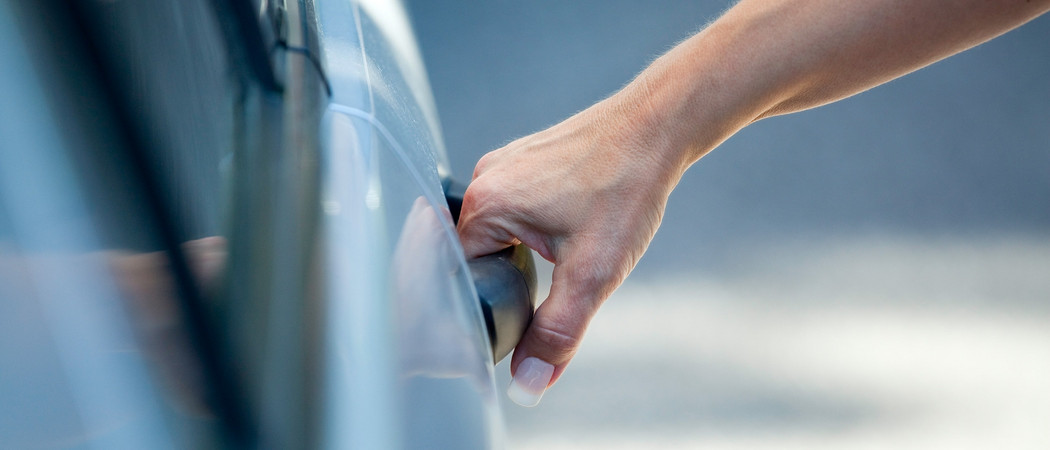 Wertermittlung beim Gebrauchtwagen - Hand öffnet Autotür.