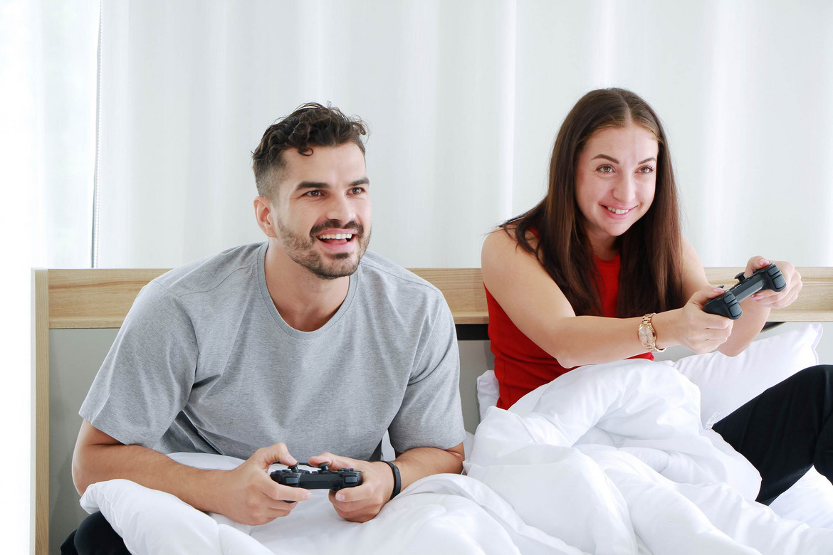 Eine junge Frau und ein junger Mann halten beide einen PS4 Controller in der Hand